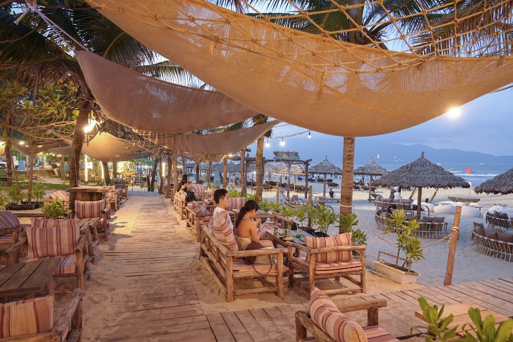 Guests relaxing at beachfront seating area at dusk
