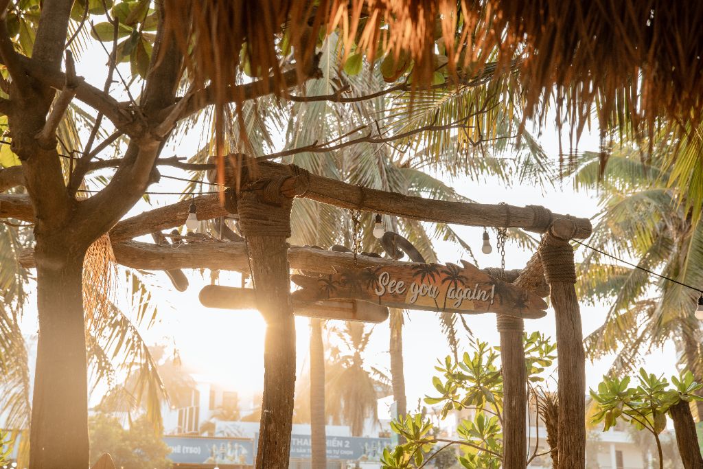 See You Again sign with golden sunlight through palm trees